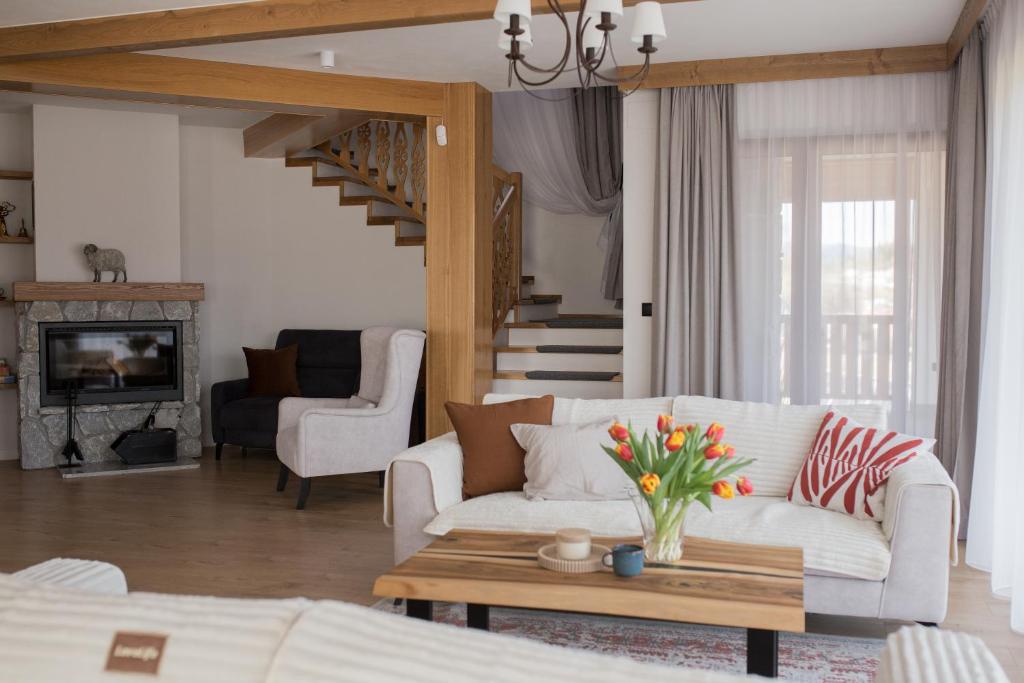 a living room with a white couch and a table at Willa Widokowe Wzgórze in Falsztyn