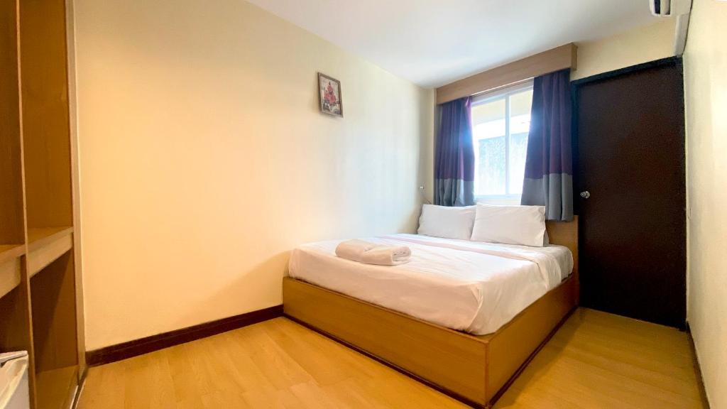 a small room with a bed with a window at Sea Place Pattaya Soi 7 in Pattaya