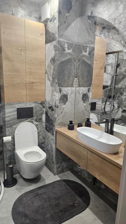 a bathroom with a white toilet and a sink at Apartament Premium in Biała Podlaska
