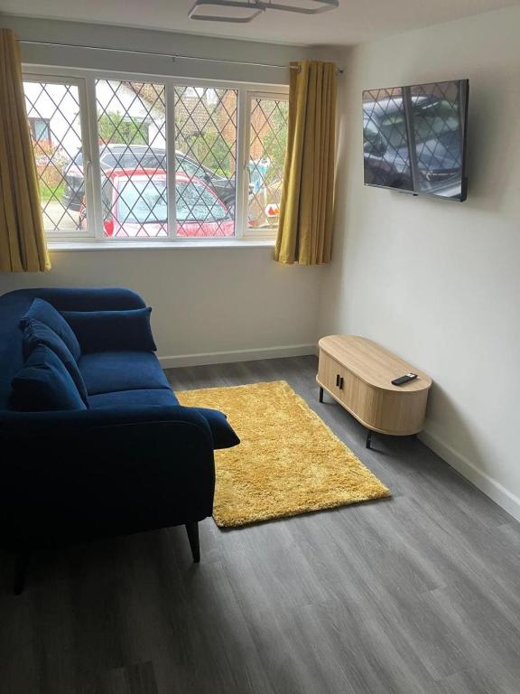 a living room with a blue couch and a rug at Newly refurbished Annexe in Wareham