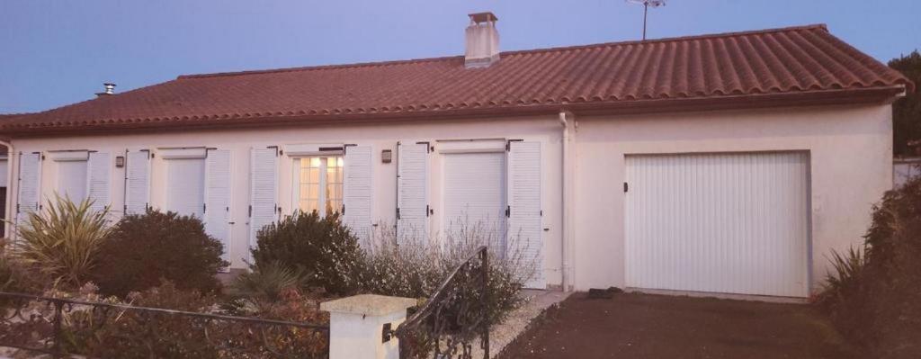 a white house with four garage doors on it at La Genetouze in La Genétouze