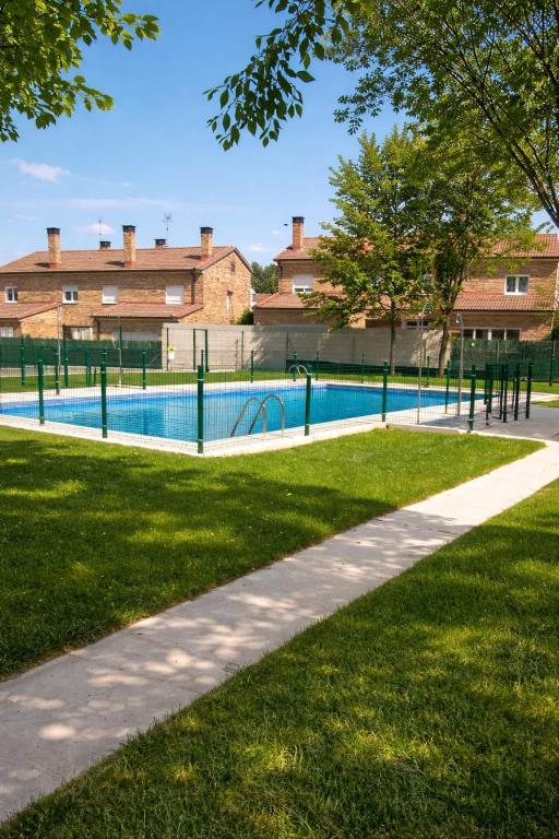 a swimming pool in a park with trees and grass at Casa any in Segovia