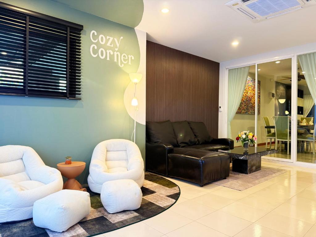 a lobby with two white chairs and a couch at THE MAISON Phuket in Ban Lo Long