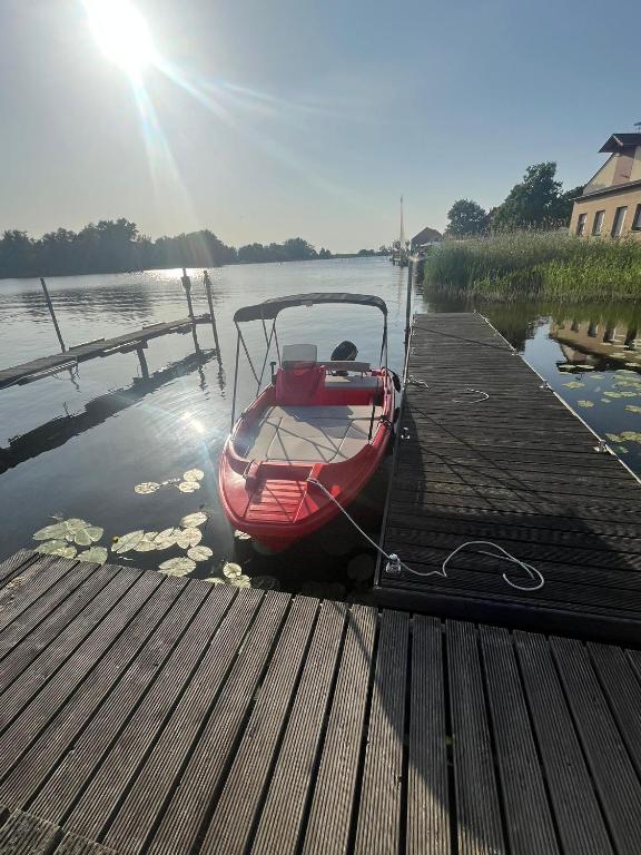 a small boat is tied to a dock at Bootshaus Pritzerbe in Kützkow