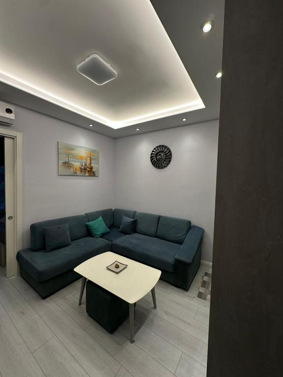 a living room with a blue couch and a table at Arli's SeaFront Apartaments in Durrës