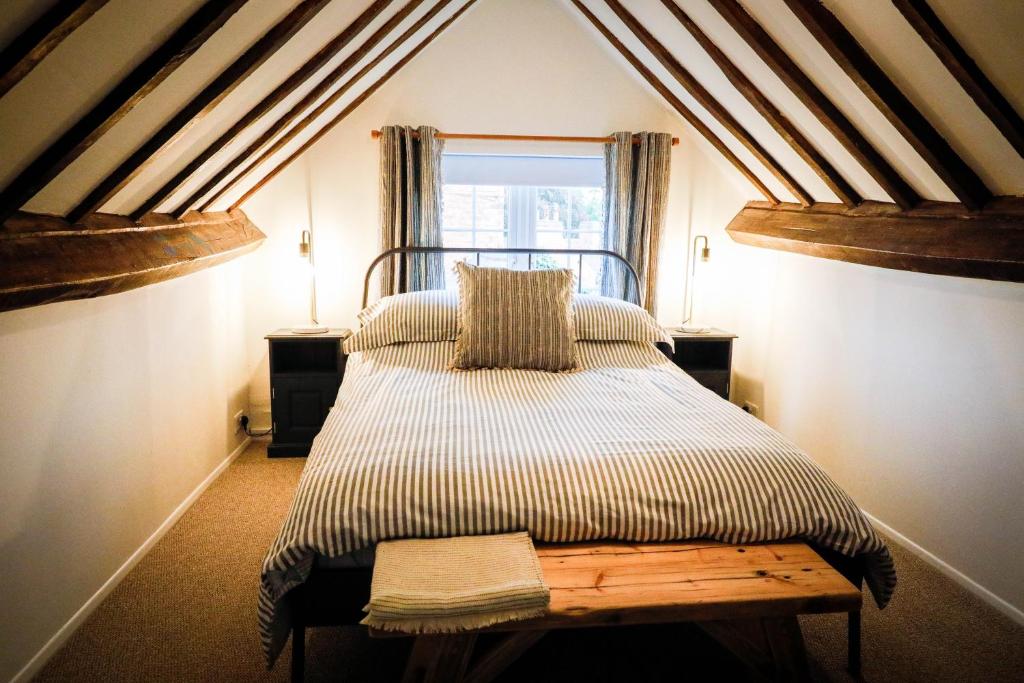 a bedroom with a bed in a attic with a window at Spacious 4 Bed House Sleeps 8 in Quorn Near Loughborough in Quorndon