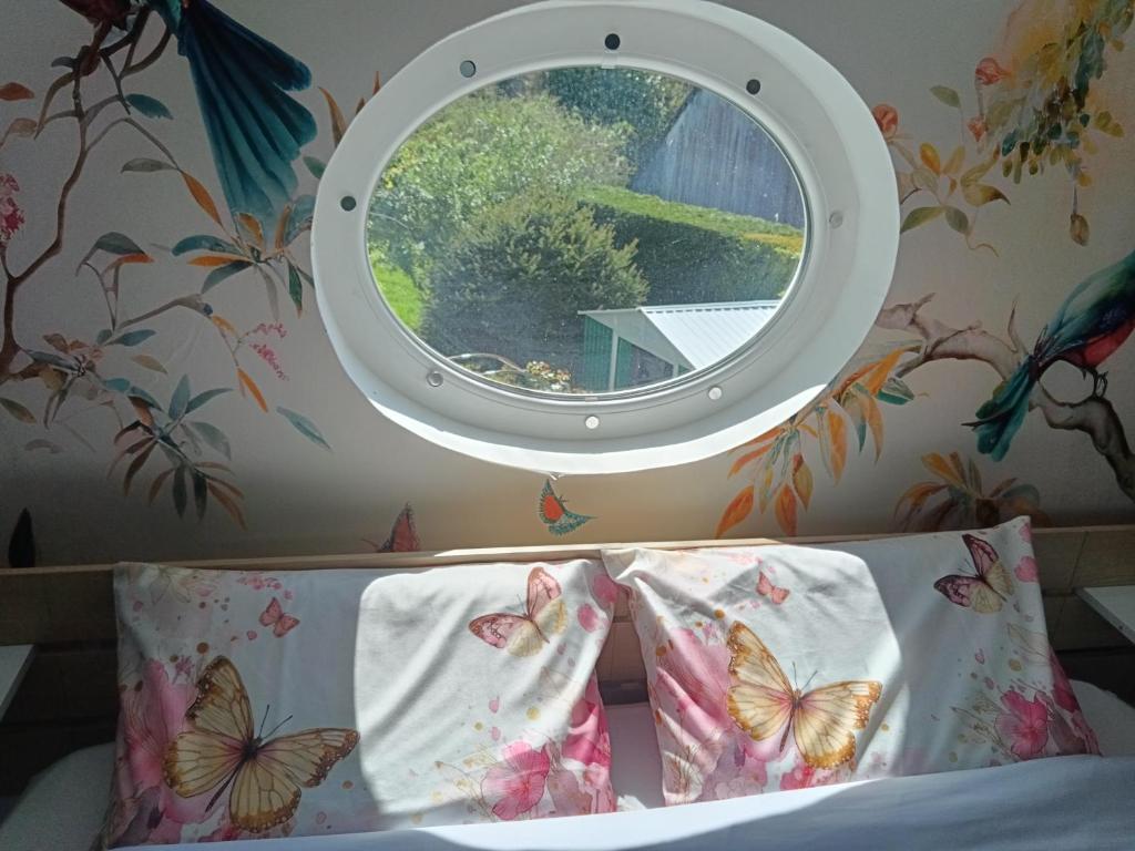 a bedroom with a window and a bed with pillows at Le clos des papillons in Carly