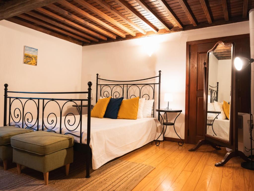 a bedroom with a bed and a chair and a mirror at Quinta de Segade in Santa Marta