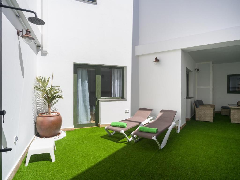 a room with green carpet and chairs and a plant at Aguadulce Agaete 1A in Agaete