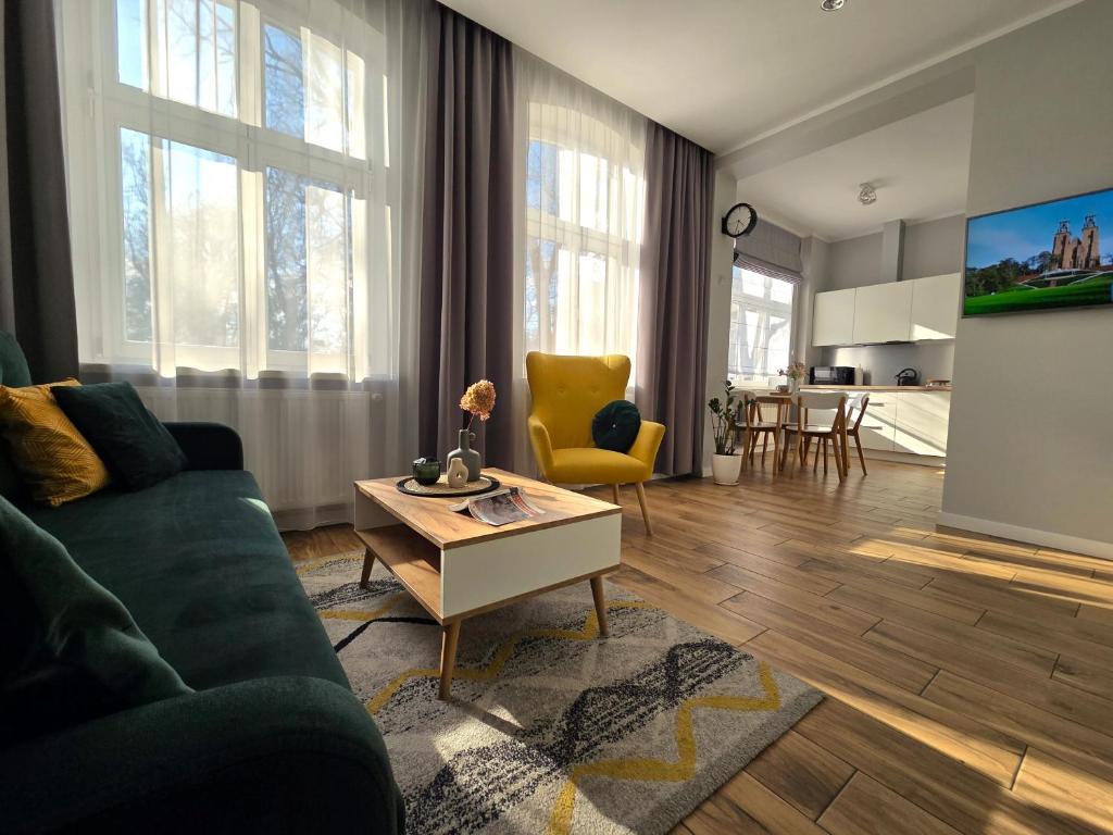 a living room with a couch and a table at Studio - Apartamenty Parkowe in Gniezno