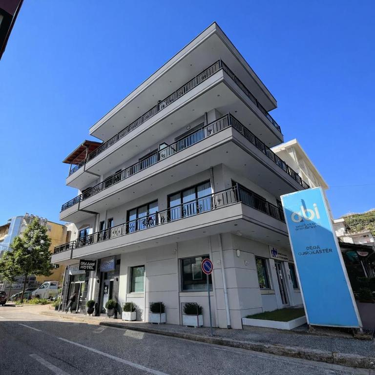 a white building with a sign in front of it at Dreams Hotel in Gjirokastër
