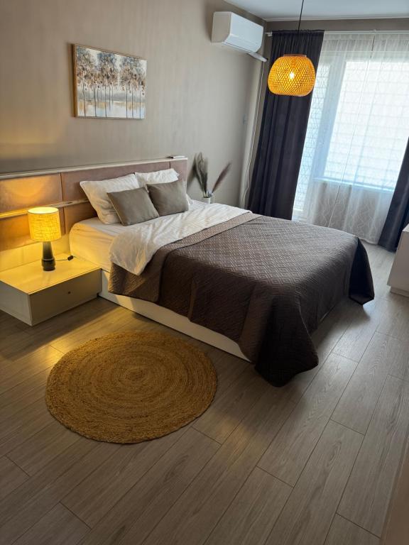 a bedroom with a large bed and a rug at Guest Apart Arda in Kŭrdzhali