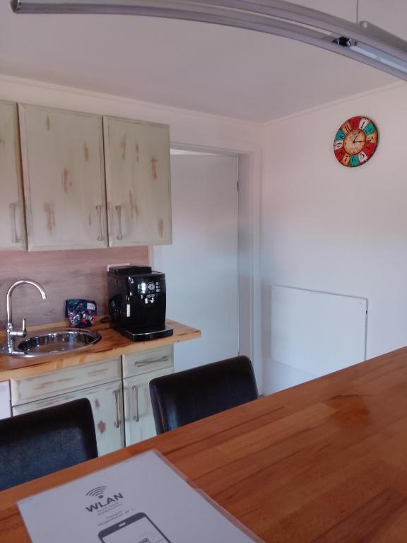 a kitchen with a sink and a counter with chairs at Heimathafen Hamelwörden in Wischhafen