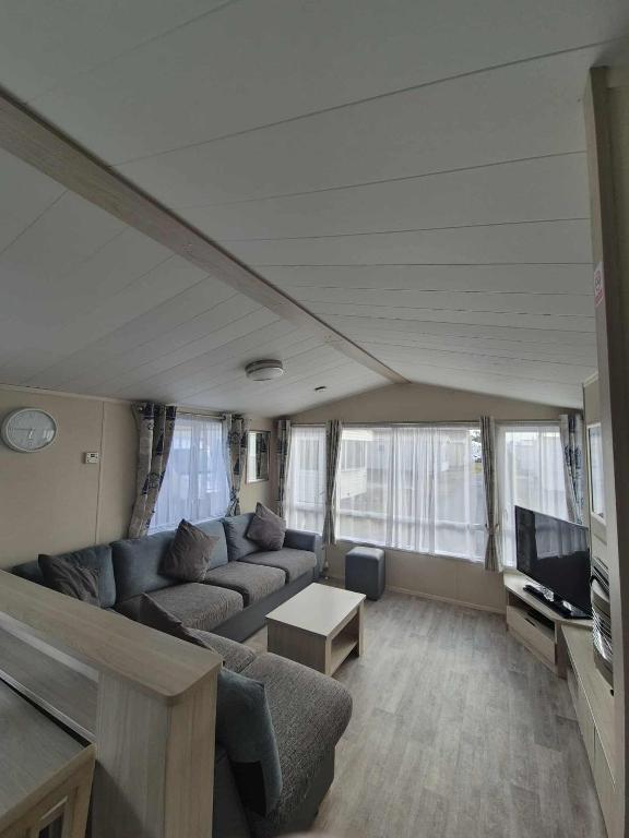 a living room with a couch and a tv at Robin hood rhyl Ll18 3uu in Rhyl