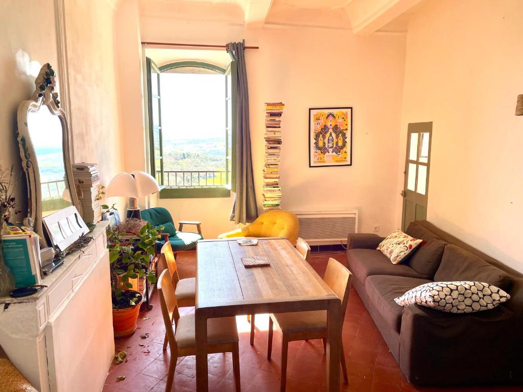 a living room with a couch and a table at Balcon sur le Luberon in Lurs