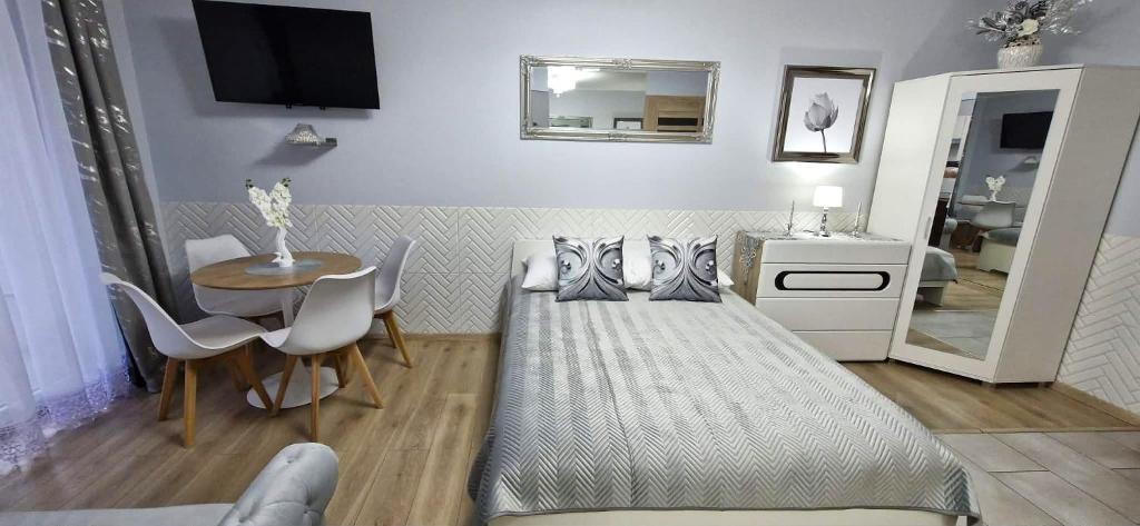 a bedroom with a bed and a table and a mirror at Apartment GLAMOUR Downtown balcony FREE PARKING SPACE in Krakow
