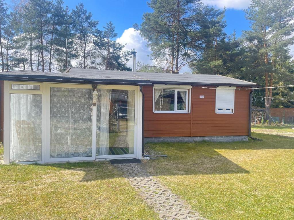 a small house with a greenhouse in a yard at Domek Zacisze całoroczny in Świętne