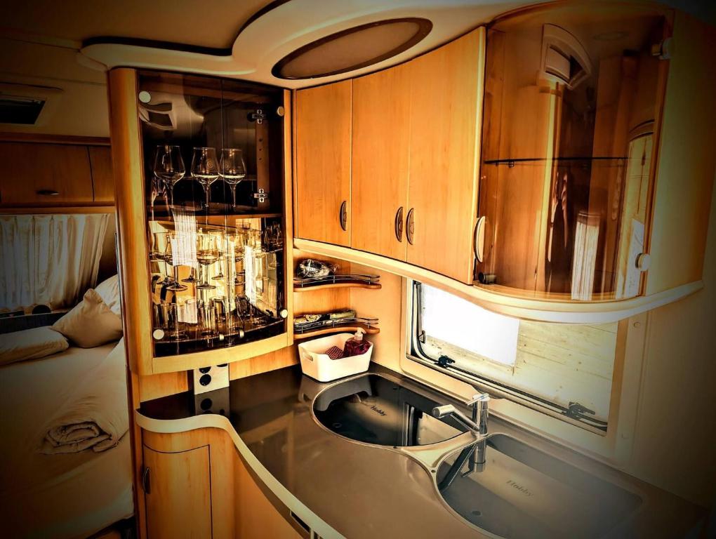 a kitchen with a sink and wooden cabinets at Charming Mobile Home Retreat in Ebbs, Austria - Tranquil Escape in Ebbs