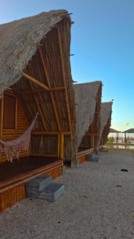 two thatched huts with a hammock in front of them at Playa Escondida Mayapo in Mayapo