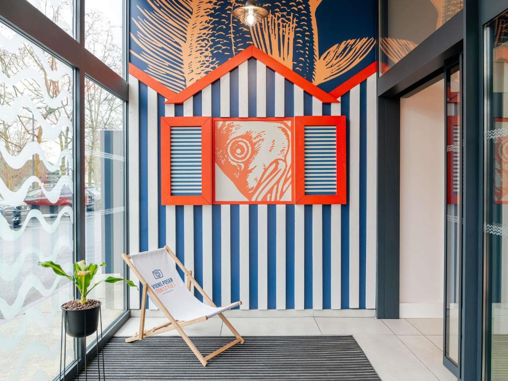 a room with a blue and white striped wall at ibis Styles Bordeaux Lac Bruges in Bordeaux