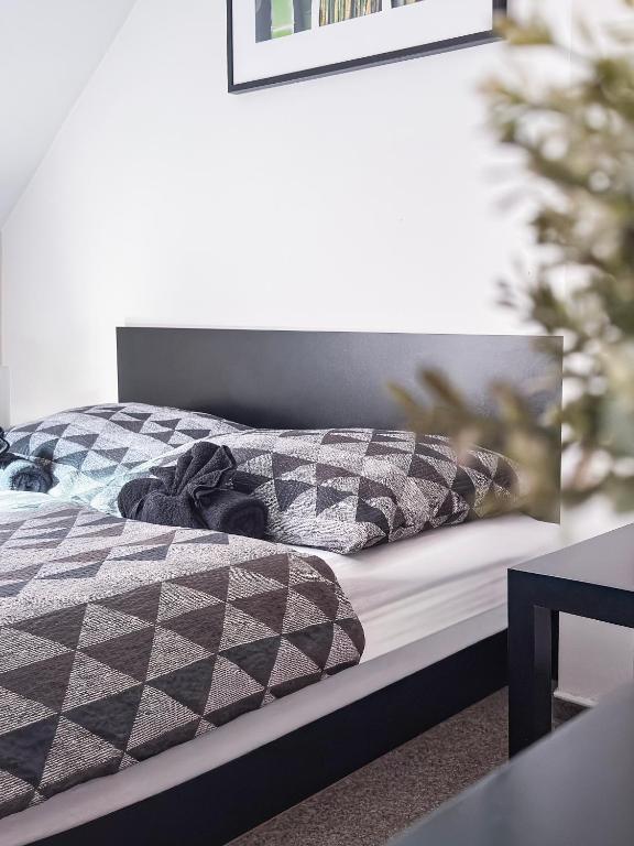 a bed with a black and white comforter and pillows at Apartmány Žalák in Ostrava