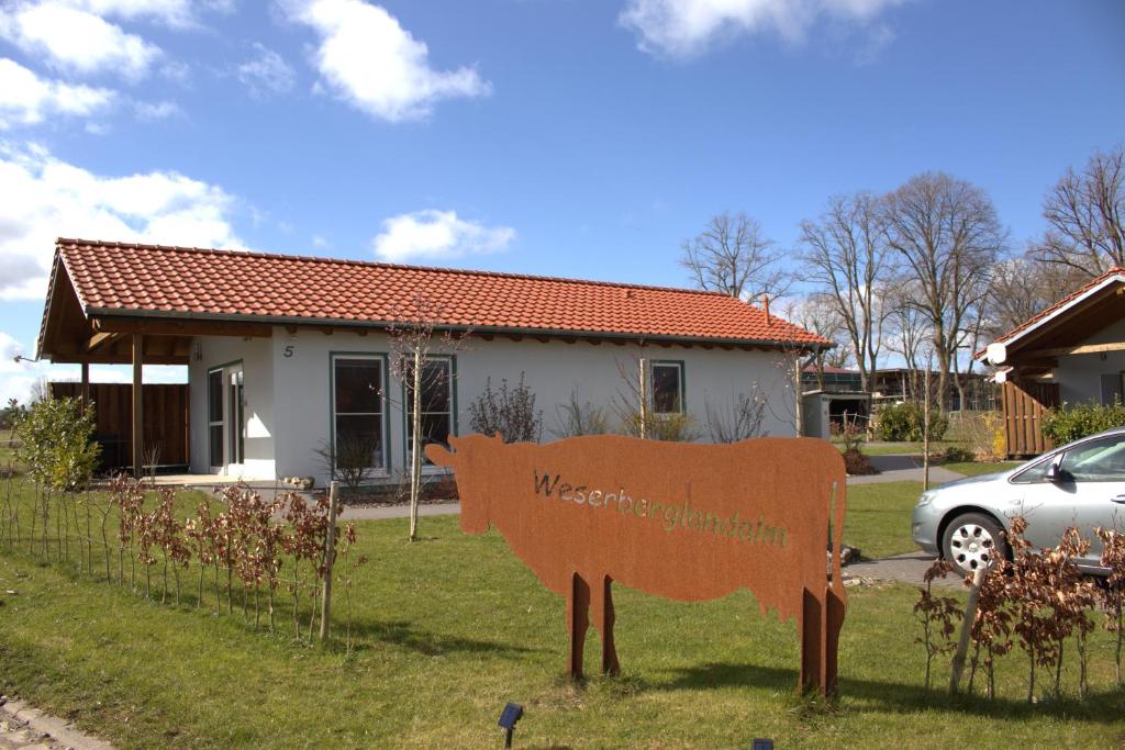 a sign in the grass in front of a house at Weserberglandalm in Ottenstein