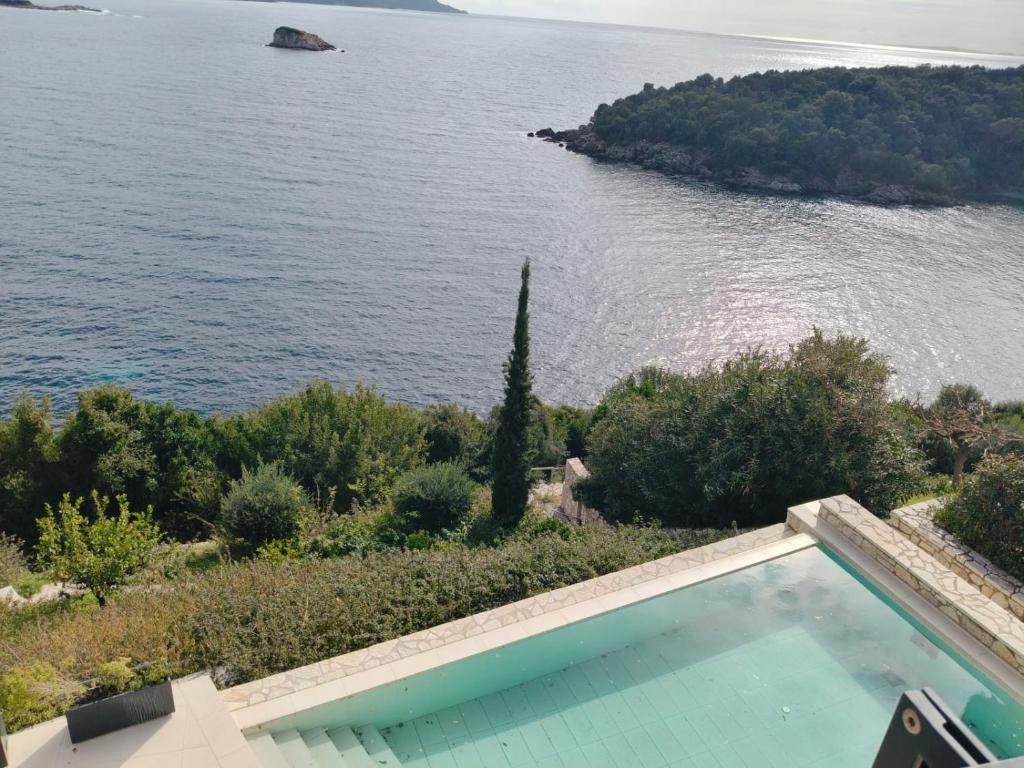 a swimming pool next to a body of water at Villa Oikos in Syvota