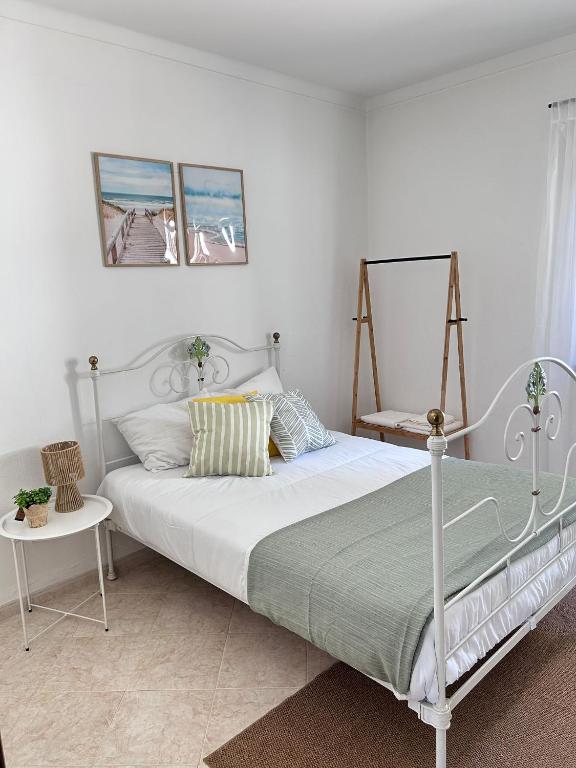 a bedroom with a bed with a white bed frame at Casa da Charrua in São Teotónio