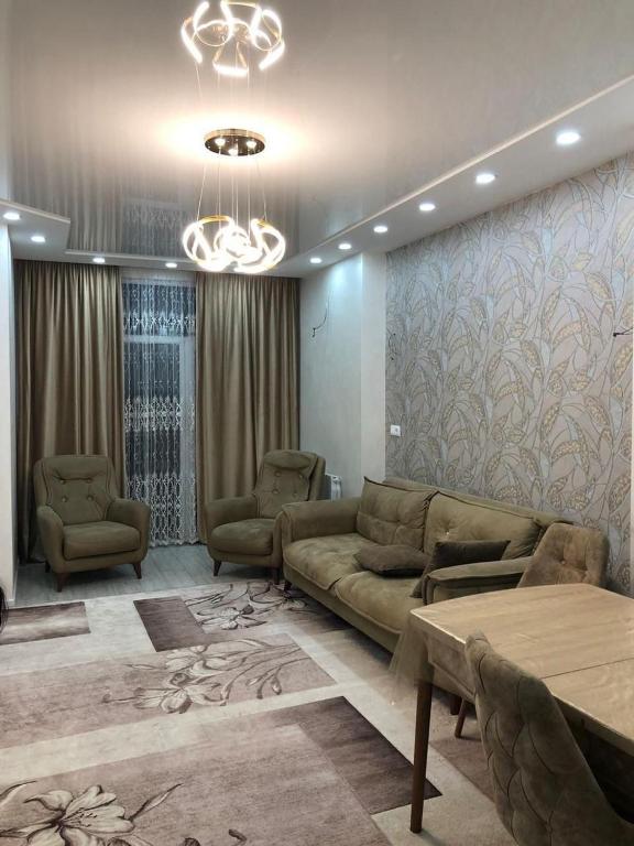 a living room with a couch and two chairs at apartment in Itʼkhvisi
