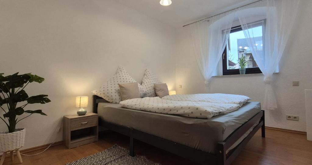 a bedroom with a bed with a window and a plant at Ferienwohnung am Töpferberg in Löbau
