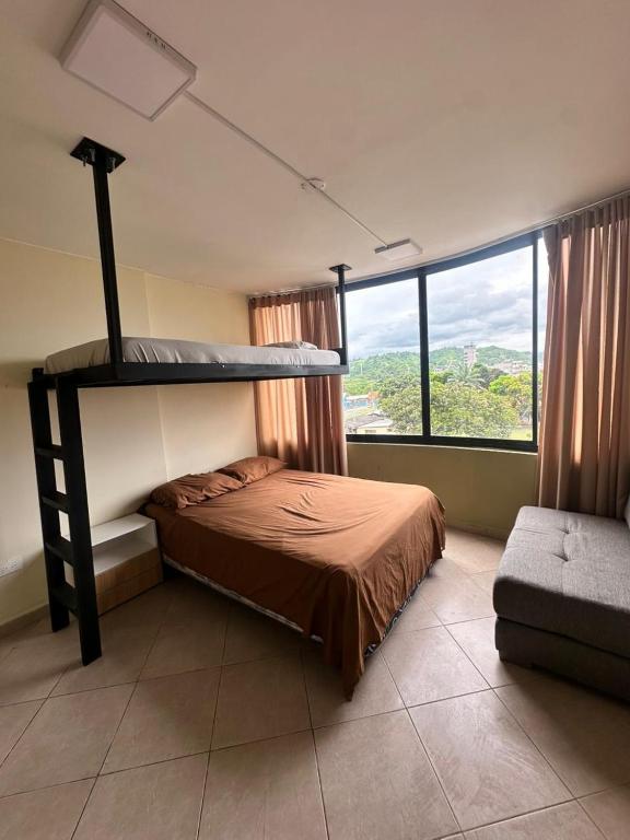 a bedroom with a bunk bed and a large window at Cozy suite and Jacuzzi overlooking the ocean in Volcán Chimborazo