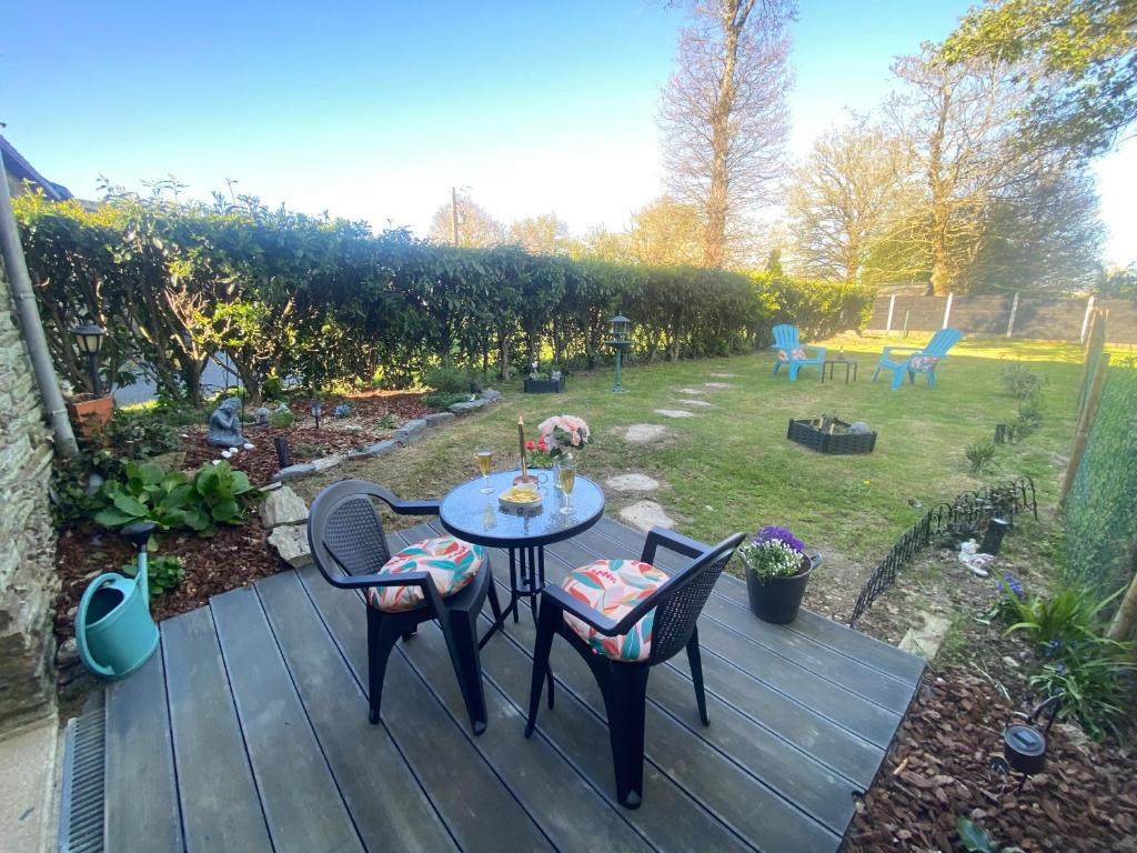 a wooden deck with a table and chairs in a yard at chez Sandrine in La Gacilly