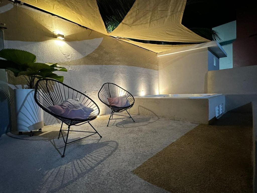 two chairs and a bench on a patio at Casa Punta Perula in Pérula