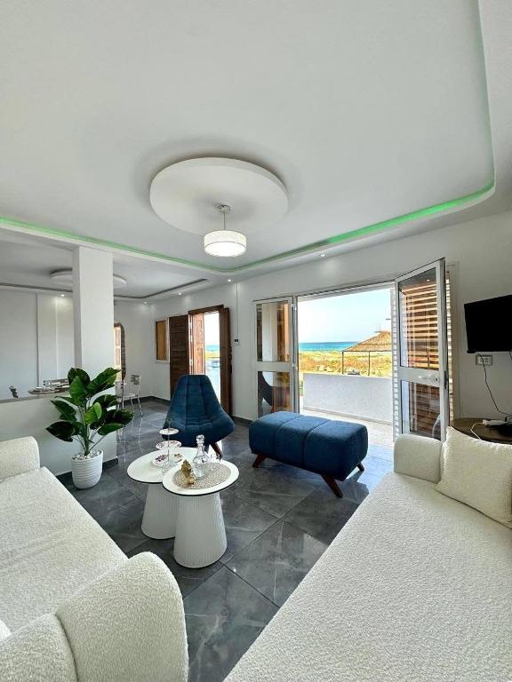 a living room with a couch and a table at Bord de Mer kelibia ezzahra in Ḩammām al Ghazzāz
