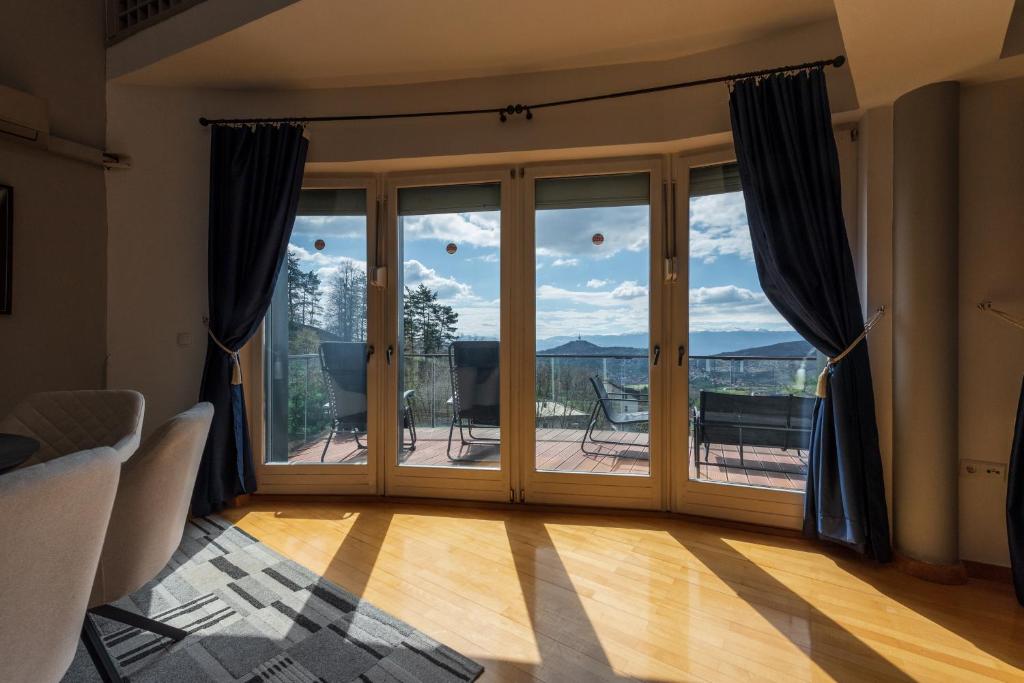 a room with sliding glass doors with a view of a deck at Villa Poljine GREEN in Sarajevo