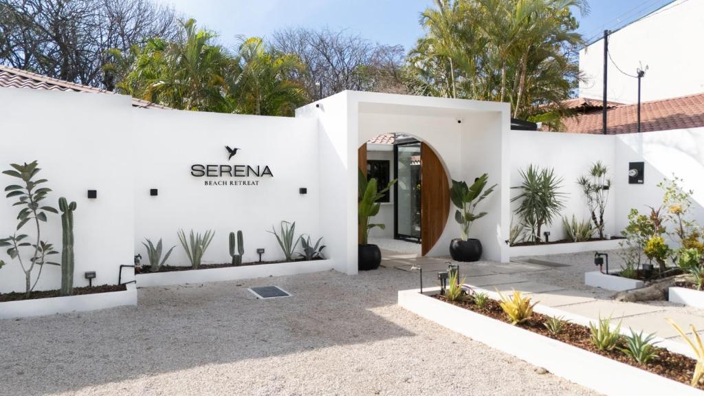 a white building with a sign that reads seren bathrooms at Serena Nosara Beach Retreat in Nosara