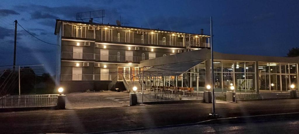 a building with lights in a parking lot at night at Europa Hotel Korinos in Korinos