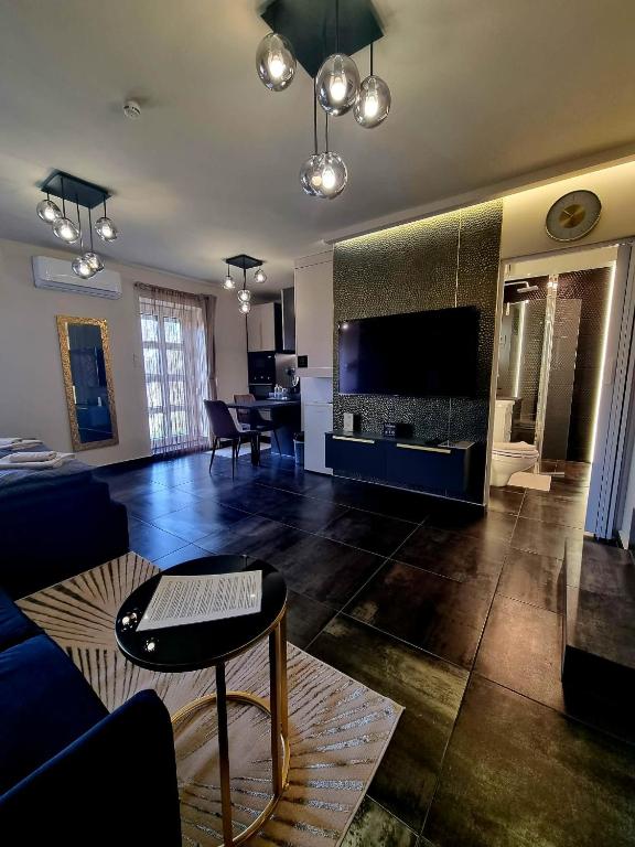 a living room with a couch and a tv and a table at MonDa apartman in Salgótarján
