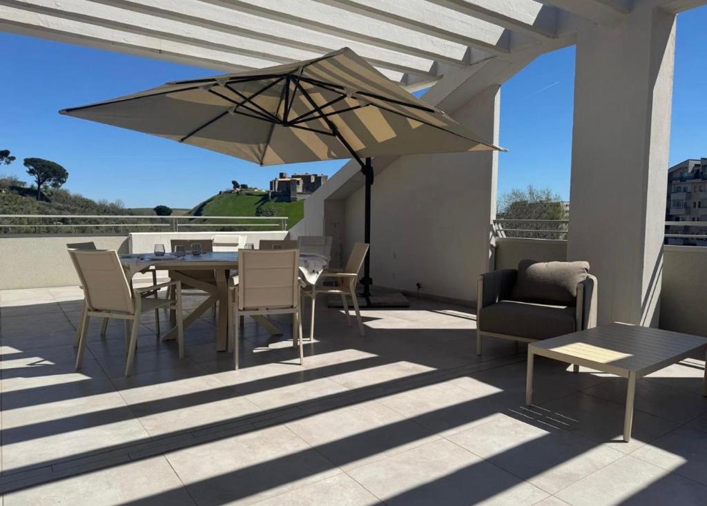 a table and chairs and an umbrella on a patio at Terrazza Belvedere in Melfi