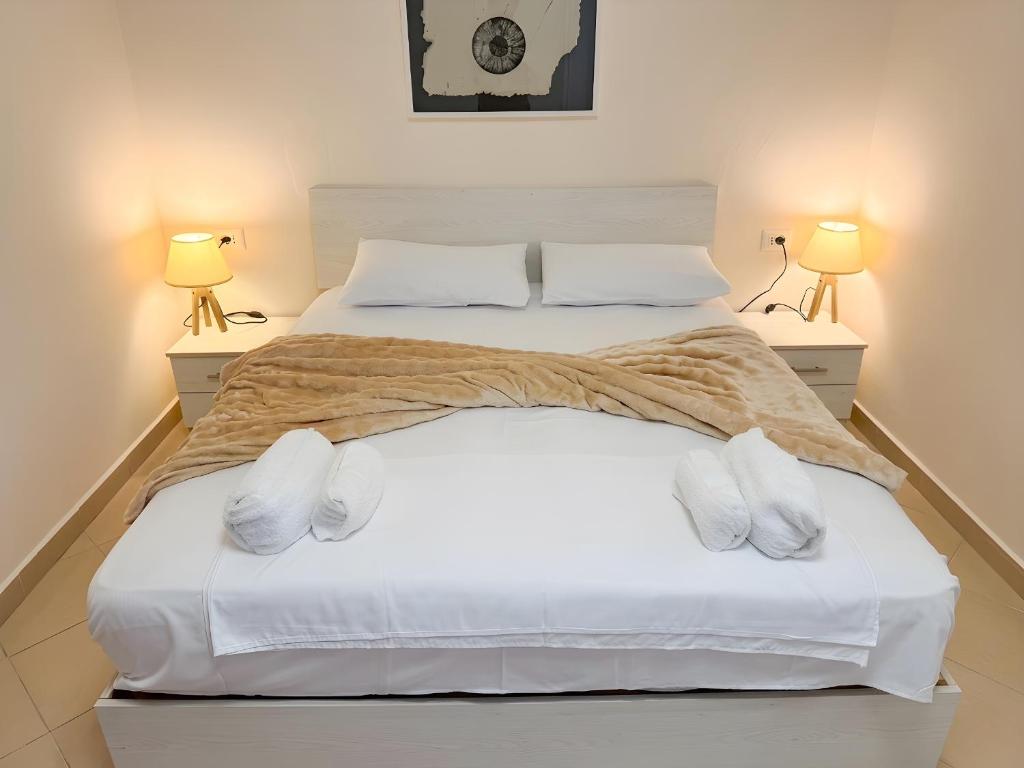 a bedroom with a large white bed with two lamps at Bogdani Apartment in Golem
