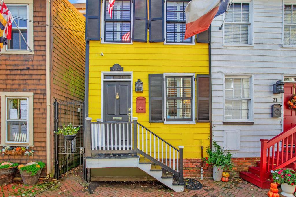 a yellow house with a staircase in front of it at Charming Rowhome in Downtown Annapolis in Annapolis
