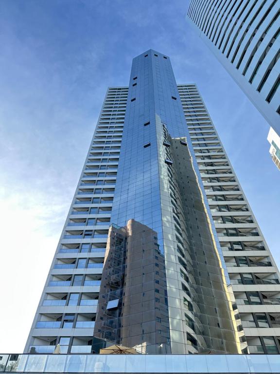 a tall glass building with a blue sky in the background at Beach Class Internacional Transamerica in Recife