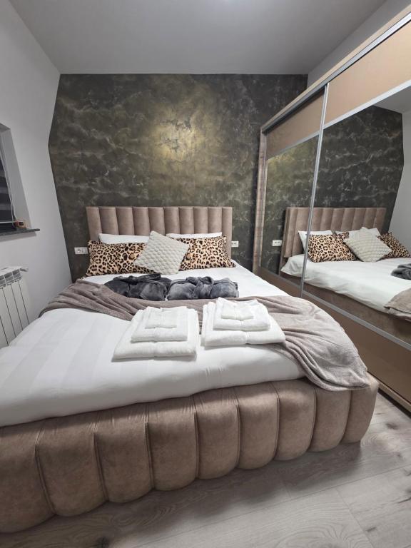 a bedroom with a large bed with two mirrors at Casa Florescu in Craiova