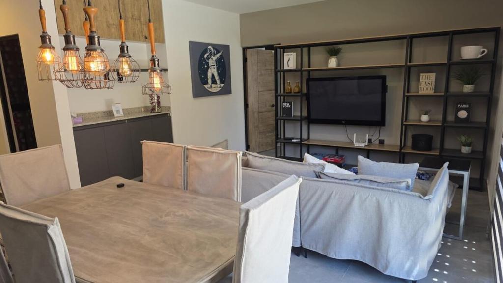 a dining room with a table and a television at Oasis privado en Querétaro in Alvarado
