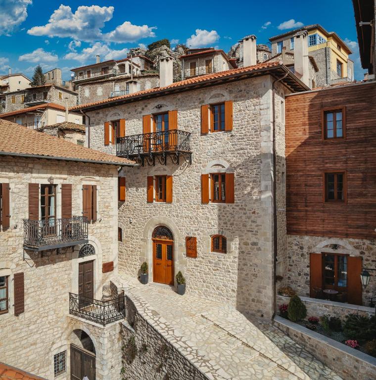 an old stone building with orange doors and buildings at Μikri Arktos Boutique Hotel in Dimitsana
