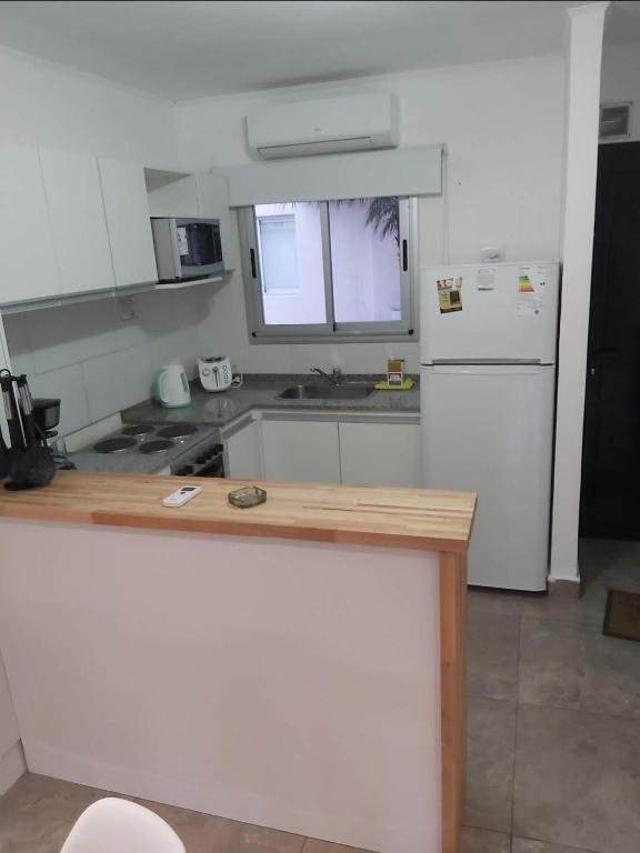 a kitchen with a white refrigerator and a counter at Amarras pinamar in Pinamar