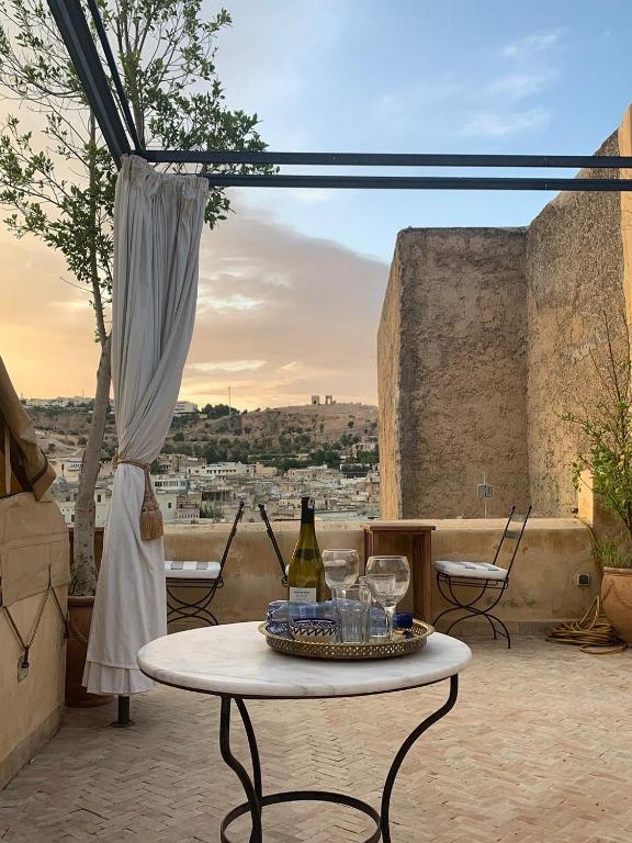 a table with wine bottles and glasses on a patio at Riad chak chak suite & spa in Fez