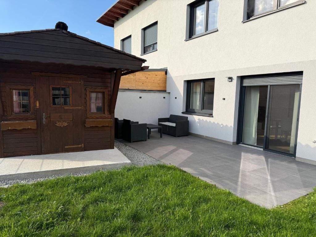 a house with a wooden door and a patio at Ferienhaus von Werner in Schlatt