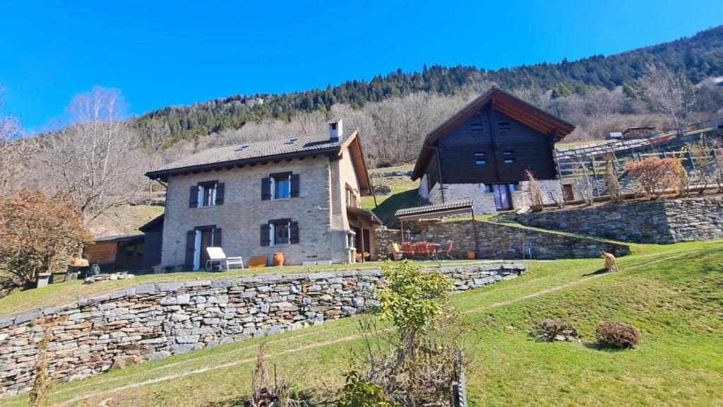 a house on a hill with a stone wall at Casa Rongia in Faido