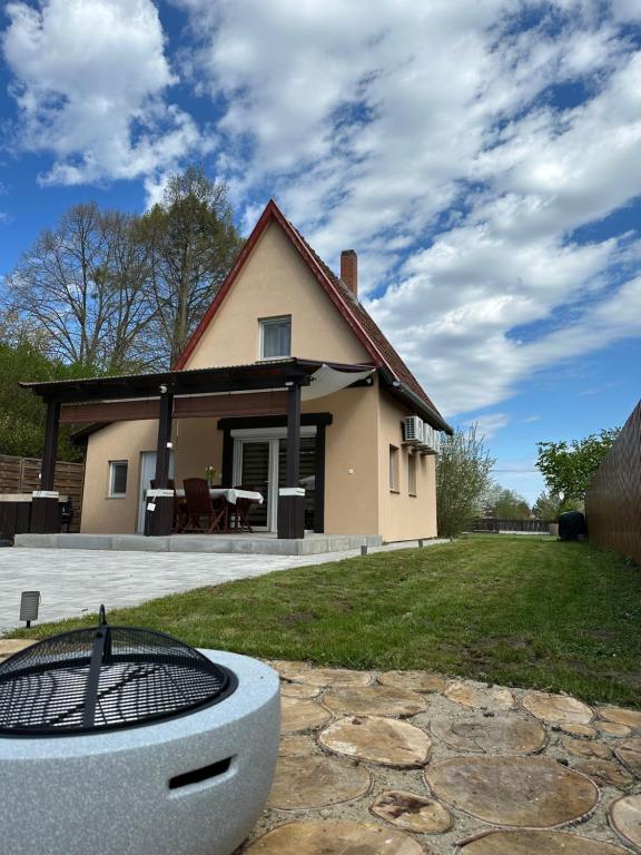 a house with a grill in front of a yard at KörösPartOn in Békésszentandrás